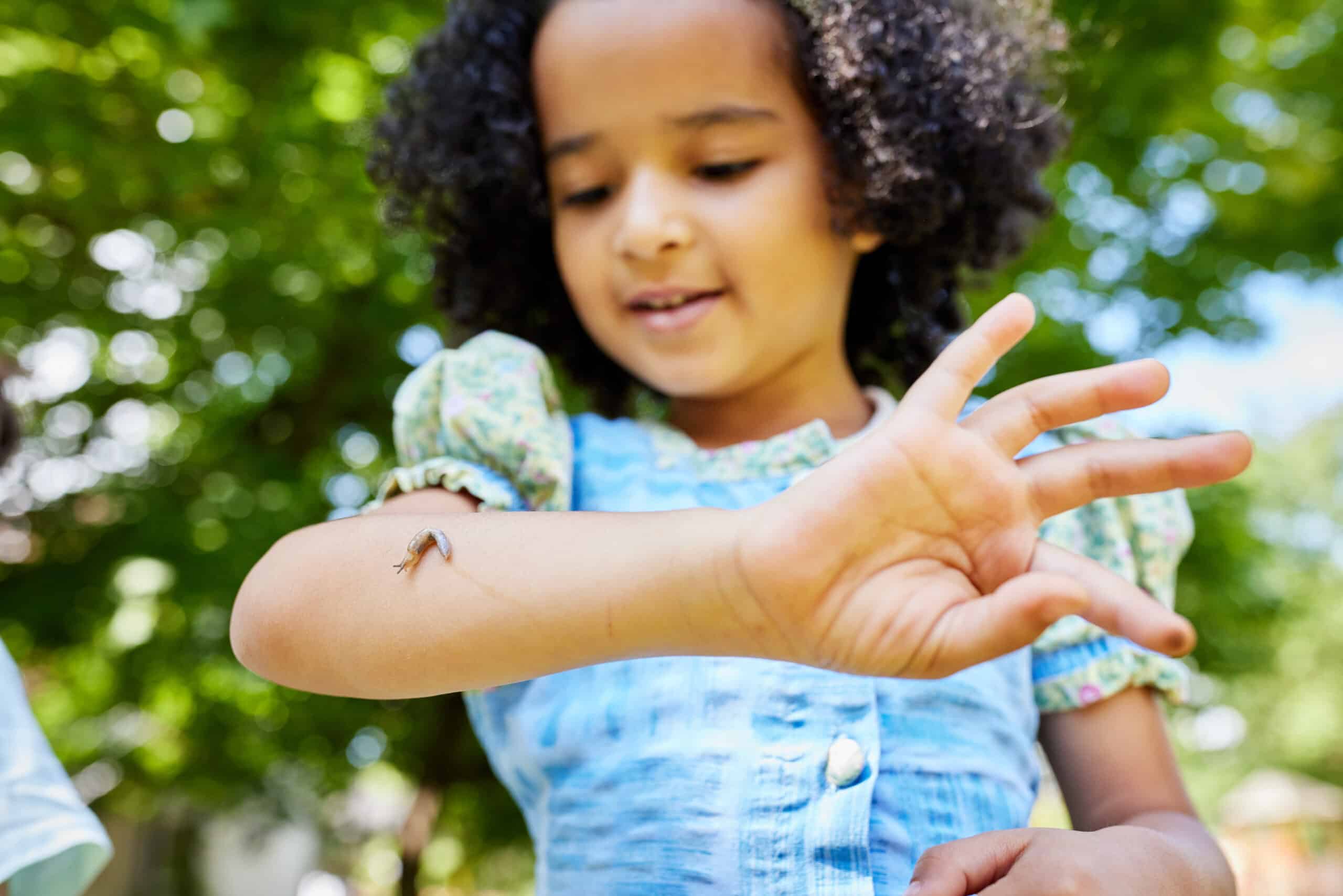 Kind mit Schnecke auf dem Arm