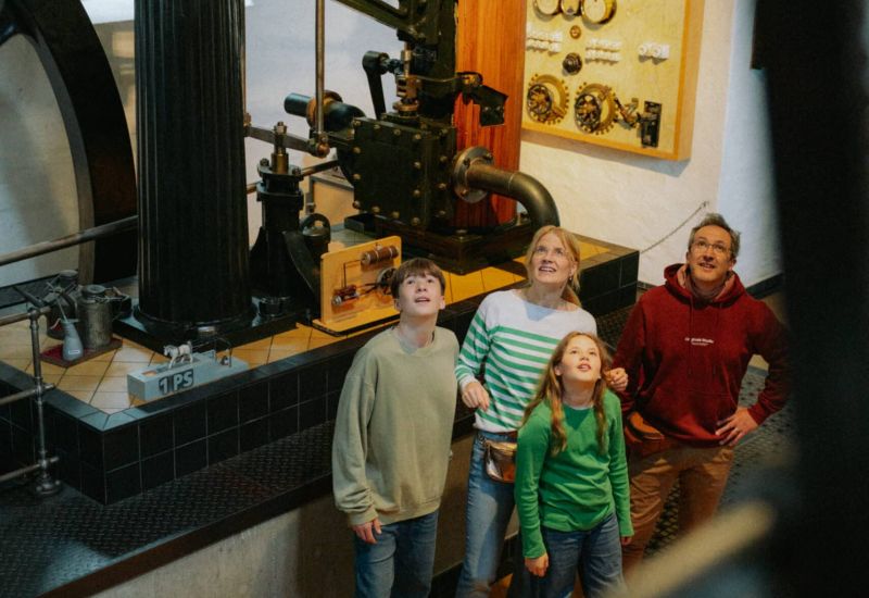 Eine Familie bestaunt die Dampfmaschine im Museum Industriekultur