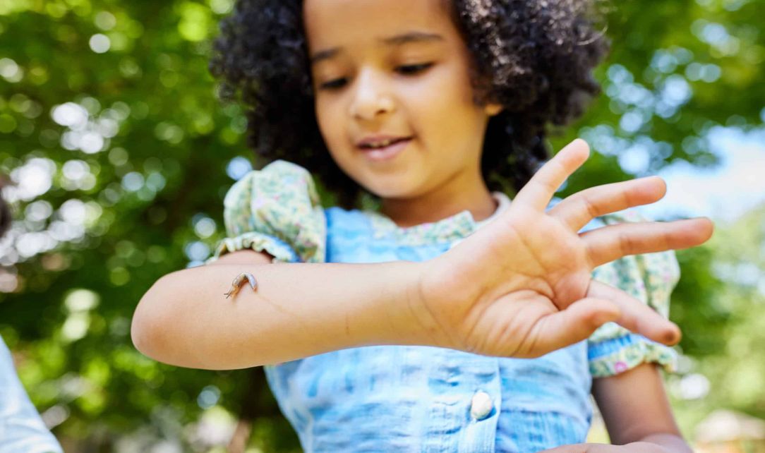 Kind mit Schnecke auf dem Arm
