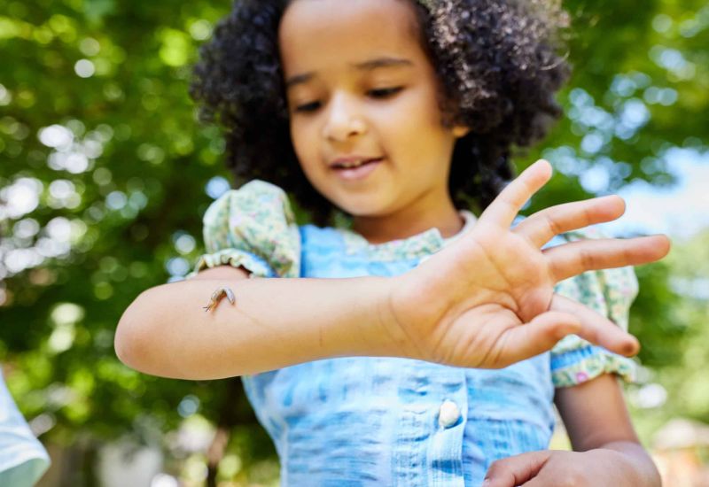 Kind mit Schnecke auf dem Arm
