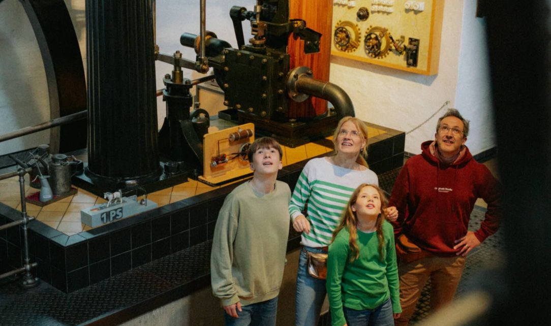 Eine Familie bestaunt die Dampfmaschine im Museum Industriekultur