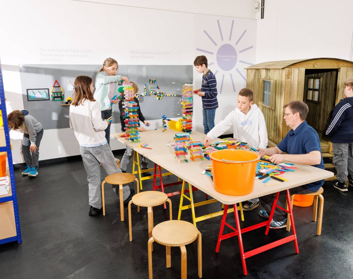 Kinder bauen mit Bauklötzen im MItmachraum der Ausstellung Zukunft Bauen im MIK