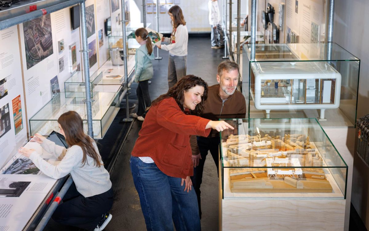 Blick in die Ausstellung "Zukunft Bauen" Menschen betrachten Objekte und Modelle